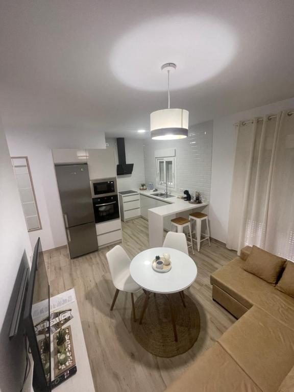 een woonkamer met een tafel en een keuken bij Apartamento Vitelio in Carmona
