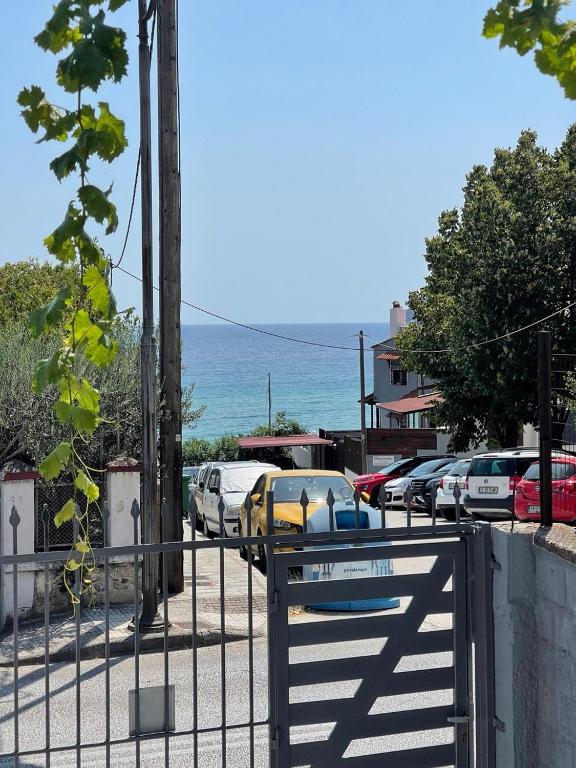 a fence next to a parking lot with cars parked at Spyros Apartment in Paleo Tsifliki