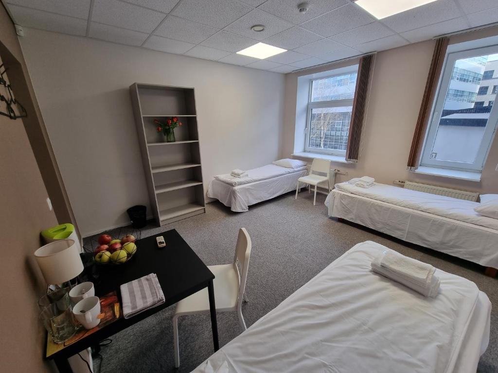 Pokój szpitalny z 2 łóżkami i stołem z owocami w obiekcie Room near City Center Harbour w Tallinnie