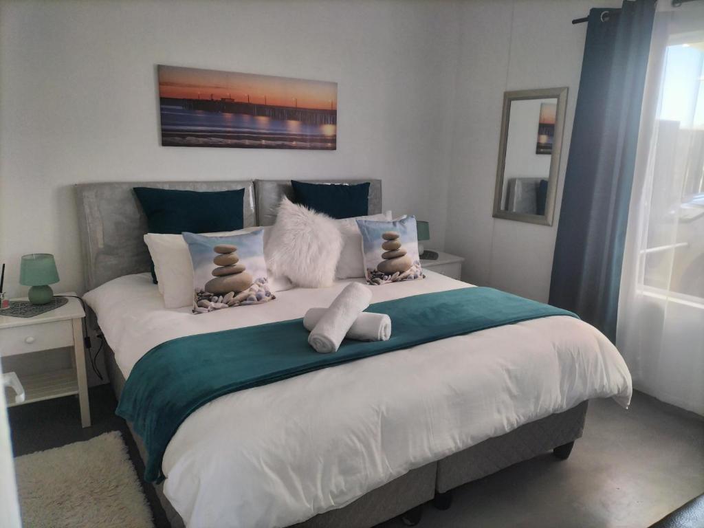 Un dormitorio con una cama grande con dos animales de peluche. en TimeOut 1, en Yzerfontein