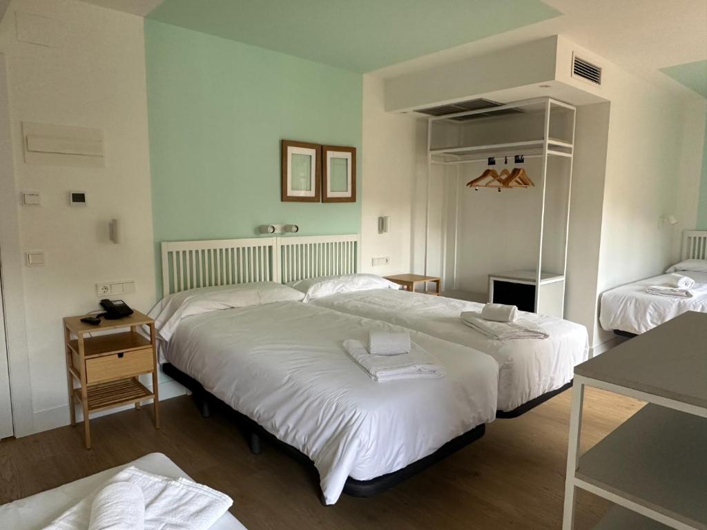 a hotel room with two beds and a table at Hotel Cangas de Onis Center in Cangas de Onís