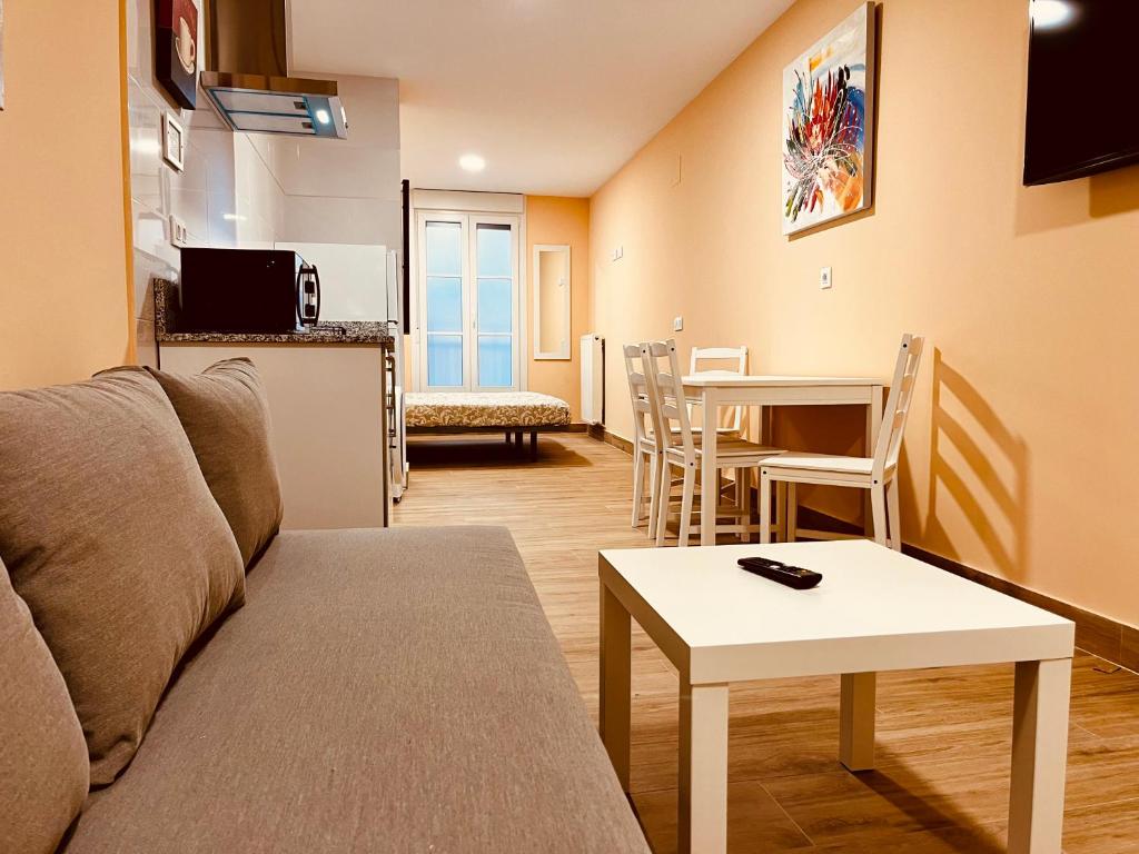 een woonkamer met een bank en een tafel bij Apartamentos San Nicolás in Logroño