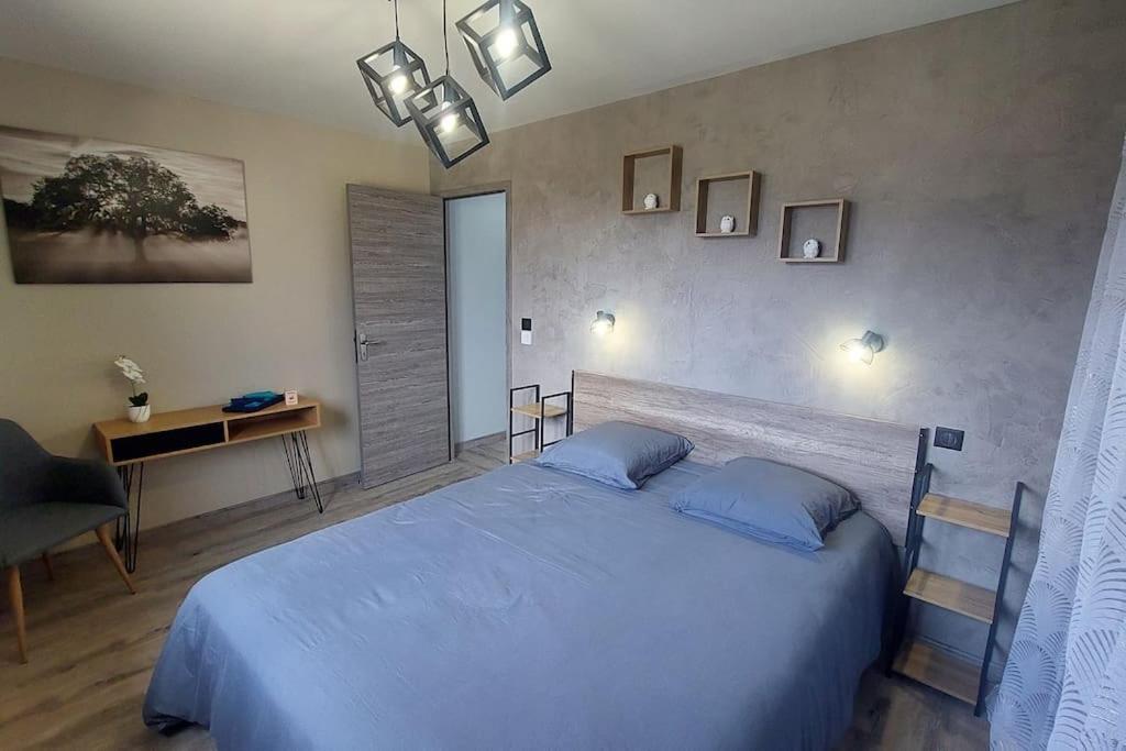 - une chambre avec un grand lit et des oreillers bleus dans l'établissement Le Panoramique, Calme - Spacieux, à Châteauroux-les-Alpes