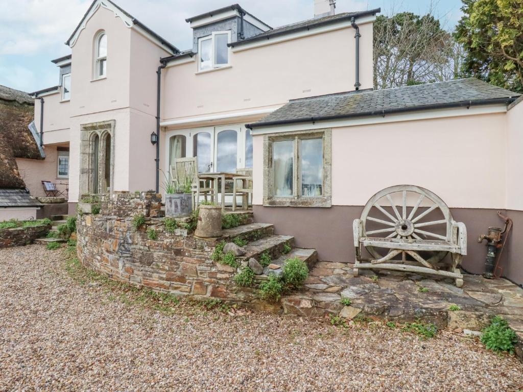 a house with a stone wall and a waterwheel at Condurro House in Truro