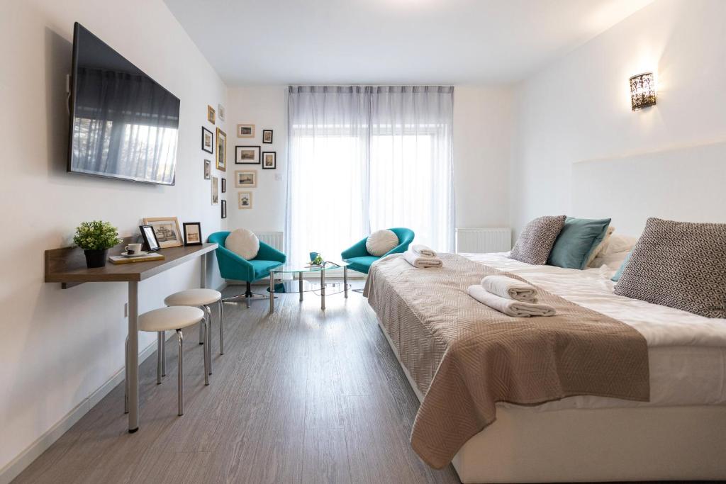 1 dormitorio con 1 cama, escritorio y sillas en Csillag Villa, en Balatonalmádi