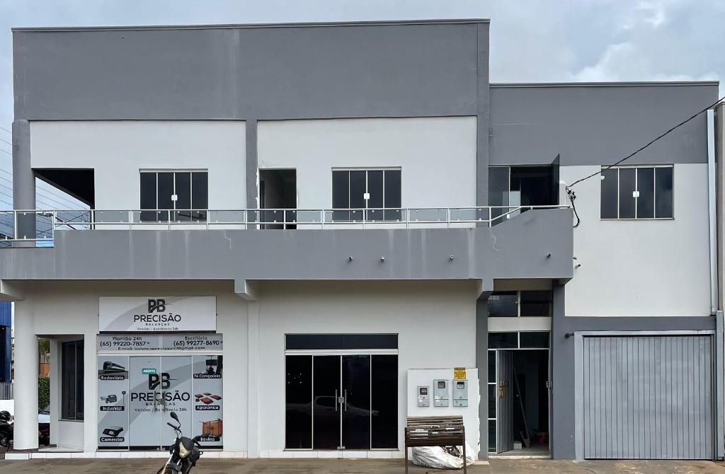 a white building with a dog in front of it at Cama & Café Parecis in Campo Novo do Parecis