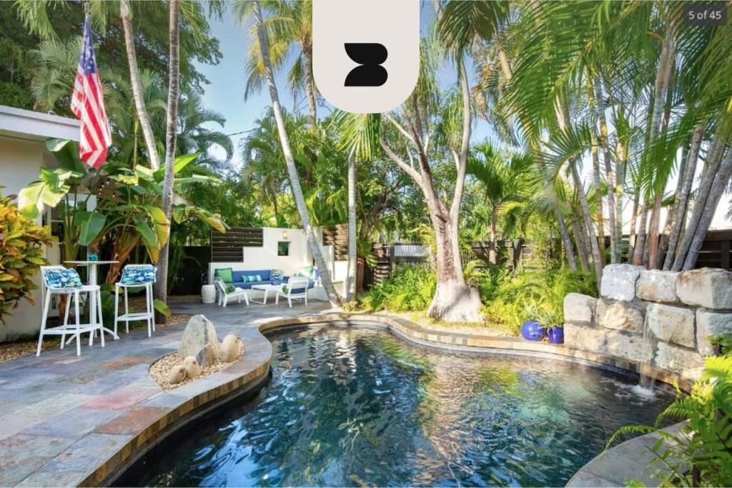 una imagen de una piscina en un patio trasero con una bandera americana en New Hidden Oasis by Brightwild- Waterfall Pool Close to Beach, en Key West
