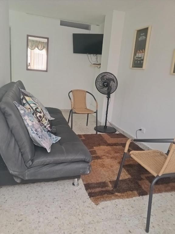 a living room with a couch and a fan at Cali Sur Centrar Apto 2 - Somos Pet Friendly in Cali