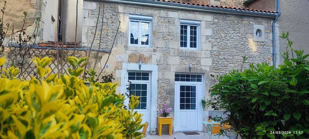 a stone building with white doors and windows at La Green Room in Poitiers
