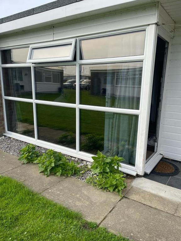 a large window on the side of a house at Seabreeze Number 74 includes swimming passes and club entry in Scratby