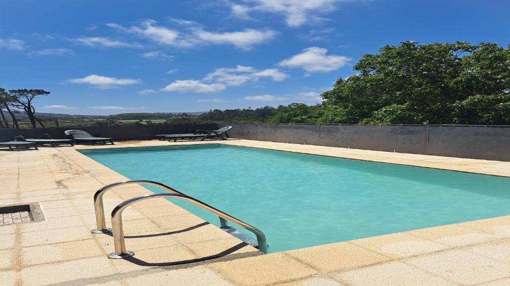 - une grande piscine avec une main courante en métal dans l'établissement Casa rústica con Piscina y finca en Costa da Morte, à Cores