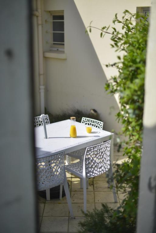 a white table and chairs with two drinks on it at Le Cottage de la Baie - vue mer en Baie de Somme in Woignarue