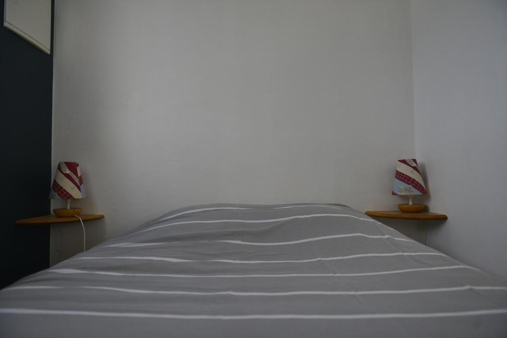 a white bed in a room with two shelves at Le Cottage de la Baie - vue mer en Baie de Somme in Woignarue