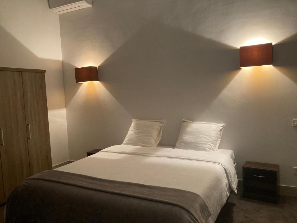 a bed in a room with two lights on the wall at De Rantere in Oudenaarde