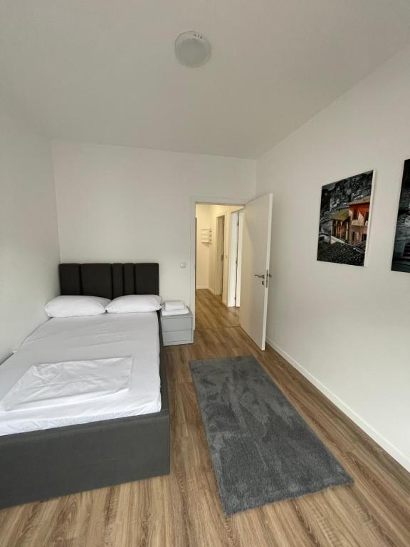 um quarto branco com uma cama e um tapete em Apartment Prishtina 038 em Pristina