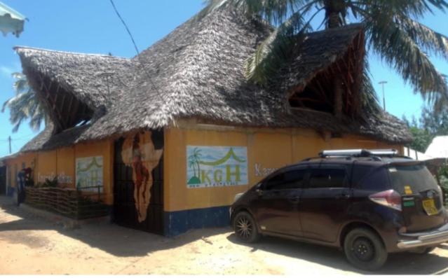 een busje geparkeerd voor een gebouw met een rieten dak bij Karemi’s Lounge Bar & Guesthouse. in Malindi