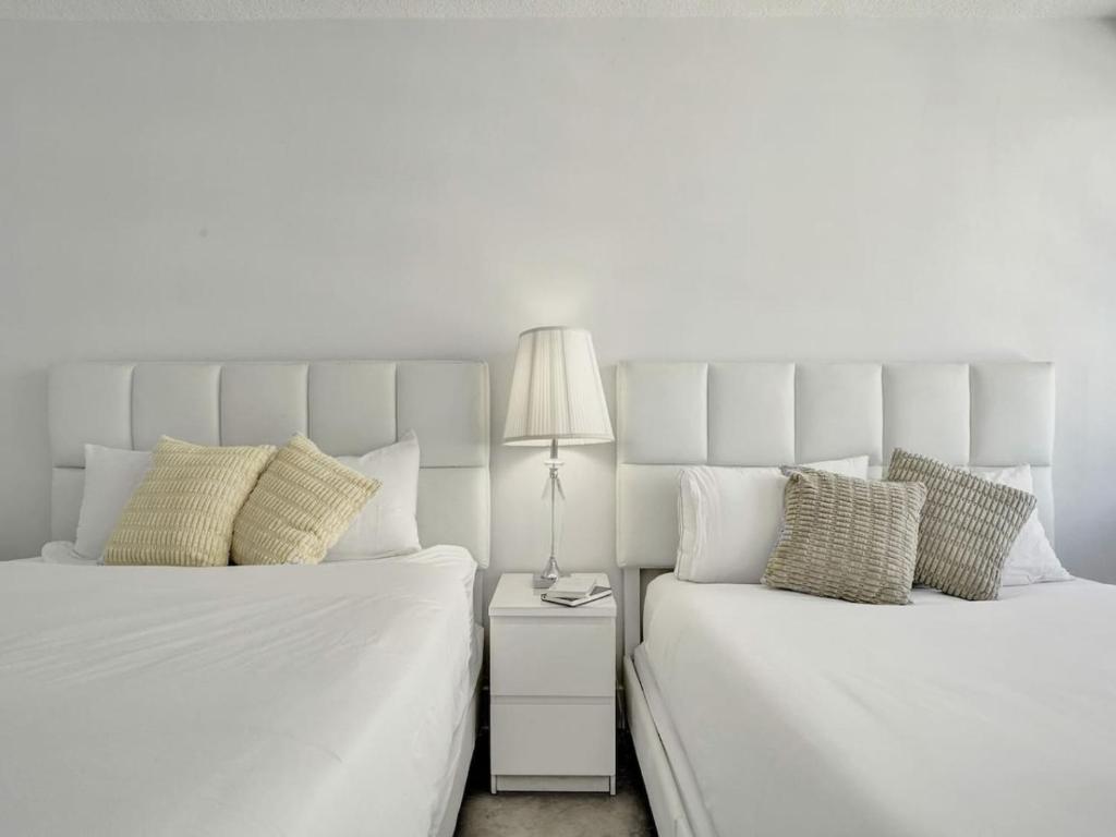 dos camas sentadas una al lado de la otra en un dormitorio en Cozy Beachfront Condo w Beach Service 1410, en Miami Beach