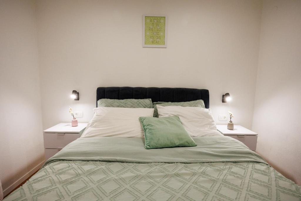 duże łóżko z zieloną poduszką na górze w obiekcie Apartment Nikoleto w mieście Zadar