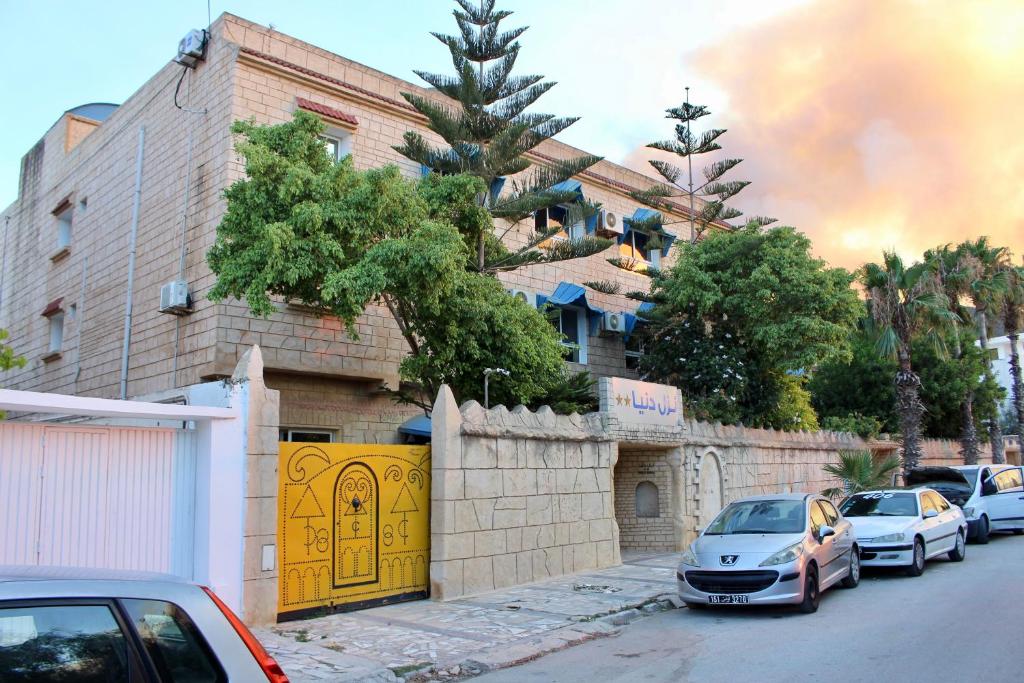 a group of cars parked in front of a building at Hotel DONIA in Hammam-Plage