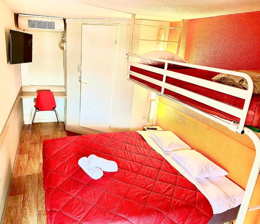 - une chambre avec des lits superposés et un couvre-lit rouge dans l'établissement Premiere Classe Laon, à Laon