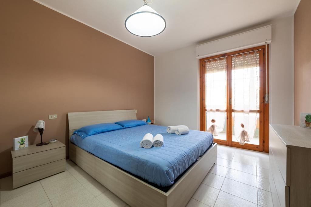 a bedroom with a bed with two towels on it at Casa Acqua Marina vicino al mare con parcheggio privato in Quartu SantʼElena