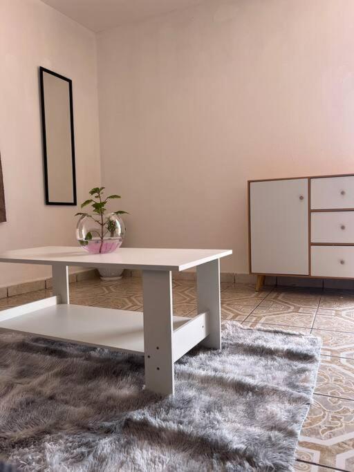 sala de estar con mesa blanca y alfombra en Departamento Zaragoza, en Chignahuapan