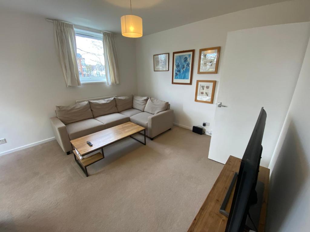 een woonkamer met een bank en een salontafel bij Richmond studio flats in Kew Gardens
