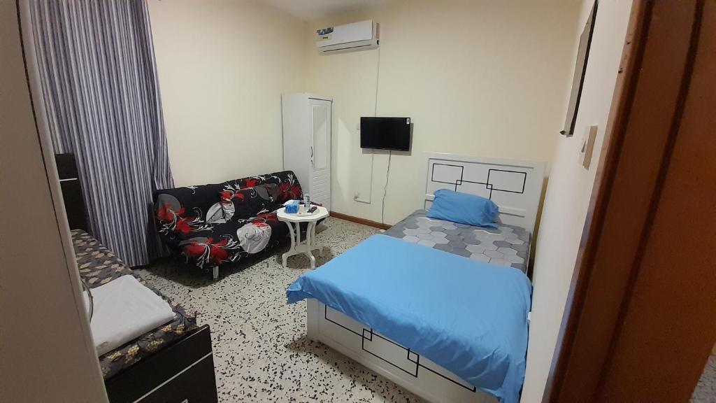 Un pequeño dormitorio con una cama y una silla. en Admf#101, en Abu Dabi