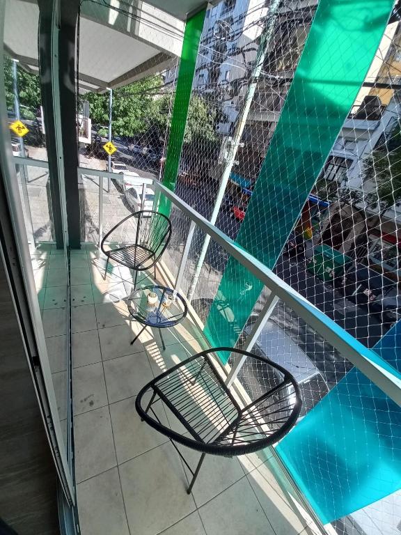 Duas cadeiras sentadas numa varanda ao lado de uma piscina em Luminoso Monoambiente en Villa Crespo em Buenos Aires