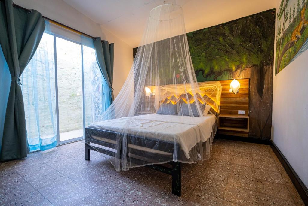 a bedroom with a bed with a mosquito net at Ambos Mundos Hotel Boutique in Taganga