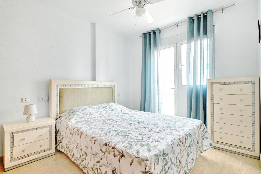 um quarto branco com uma cama e uma janela em Palacio Del Mar em Torrevieja