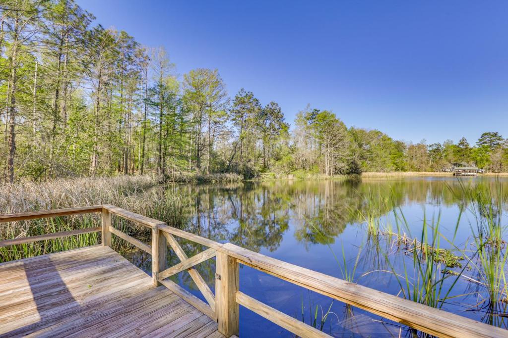 un paseo marítimo de madera sobre un lago con árboles en Bainbridge Home with Cove and Lake Seminole Access!, en Bainbridge