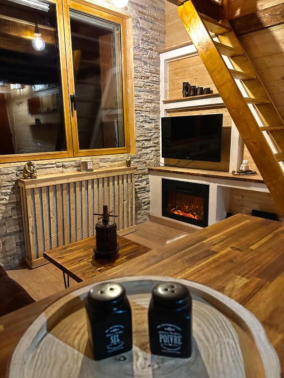 un salon avec une table et une cheminée dans l'établissement Petit Ours Blanc, à Gréolières