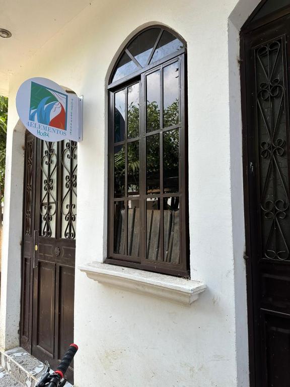 a building with a window and a sign on it at 4 Elementos Hostal in San Juan La Laguna