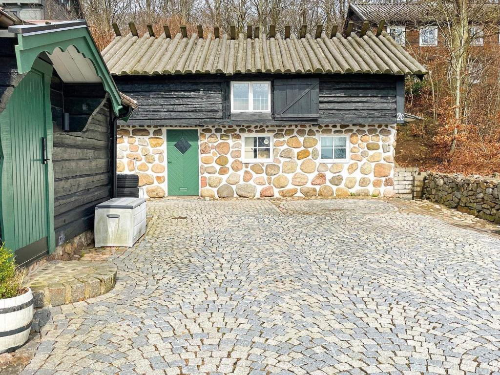 a brick building with a green door and a stone driveway at Holiday home BÅSTAD II in Båstad