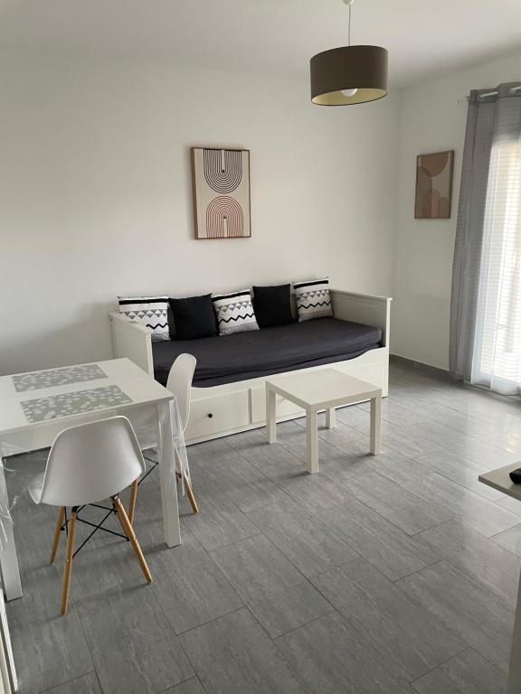 uma sala de estar com um sofá e uma mesa em Appartement t2 avec terrasse et cour em Cavaillon