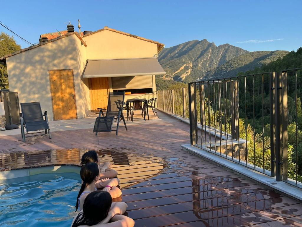 a group of people sitting in a pool on a deck at CASA SAPEIRÓ - Allotjament Rural in Cellers