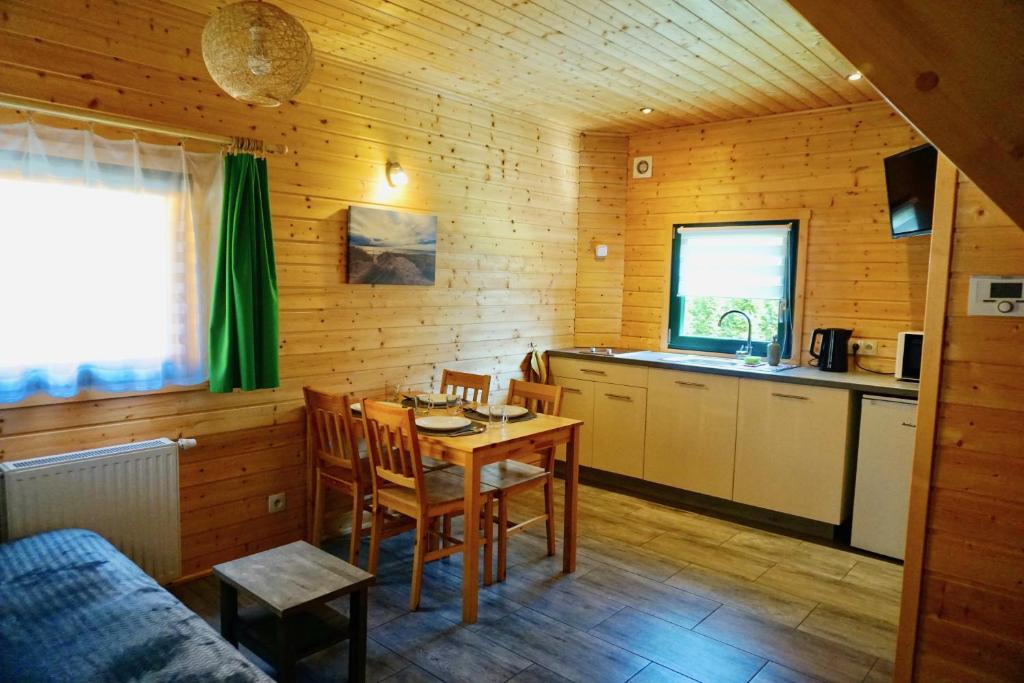 a kitchen with a table and chairs in a room at Zielone Domki in Pobierowo