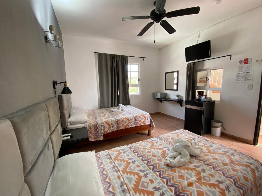 a bedroom with two beds and a ceiling fan at Hotel Marcianito in Isla Mujeres