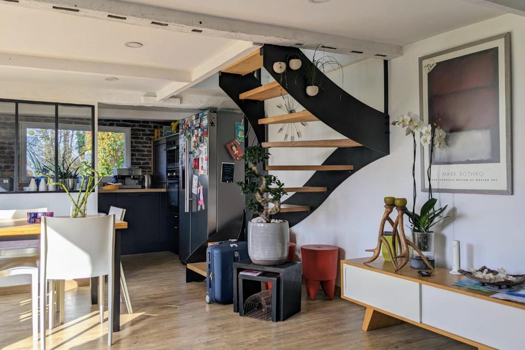 uma cozinha e sala de estar com uma escada em espiral em Norman house with jacuzzi em Touques