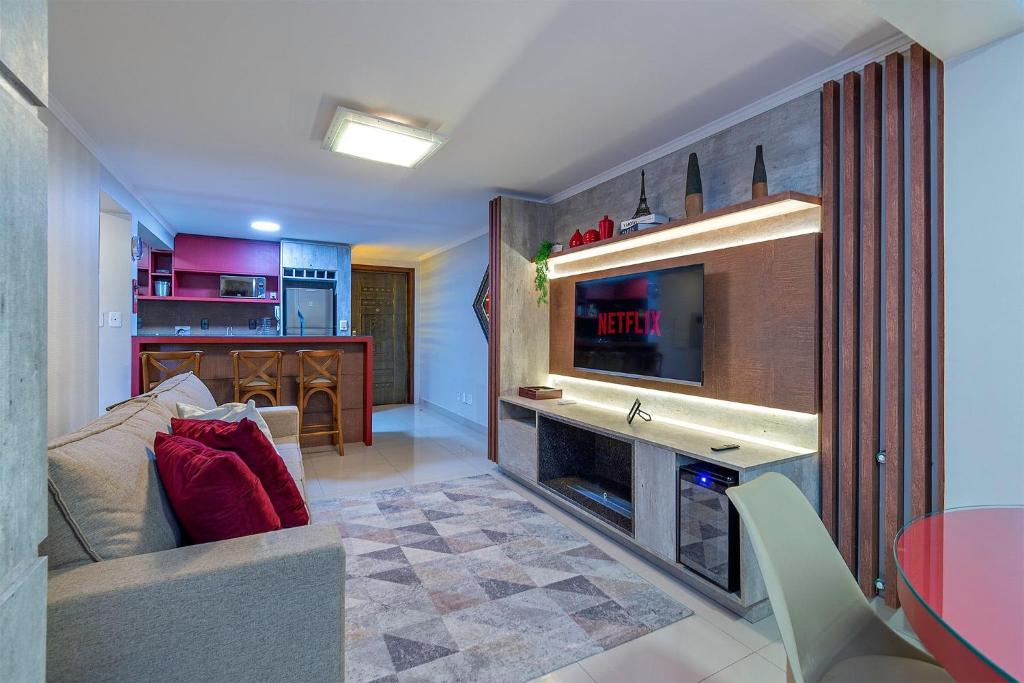 uma sala de estar com um sofá e uma televisão em Don Raul - Stay House Temporada em Canela