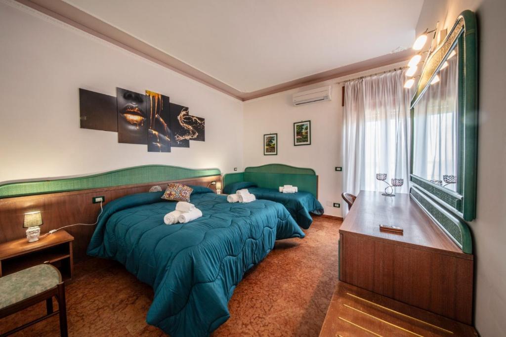 two beds in a room with green sheets at SUITE APARTMENT TAORMINA in Taormina