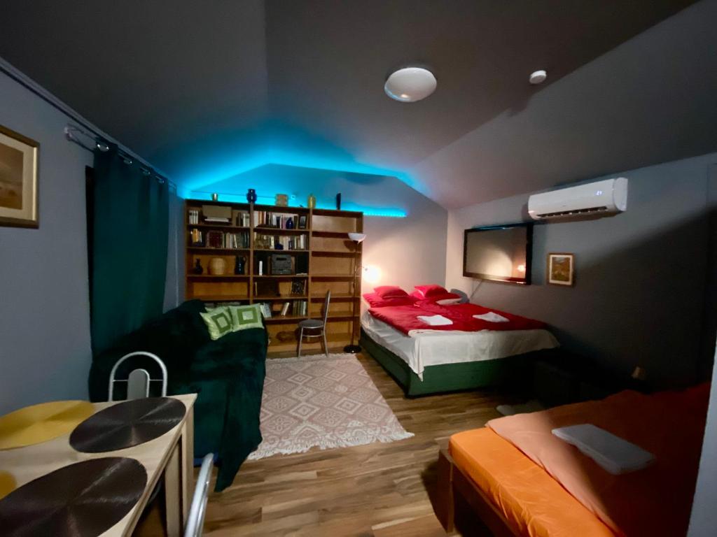Cette chambre comprend deux lits et une lumière bleue. dans l'établissement Babér Apartmanház Balatonakarattya, à Balatonkenese