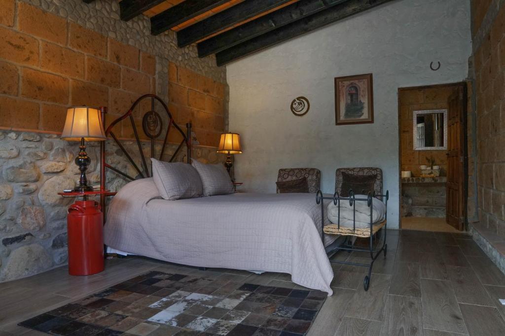 a bedroom with a bed in a stone wall at Armadillo Mágico in Armadillo