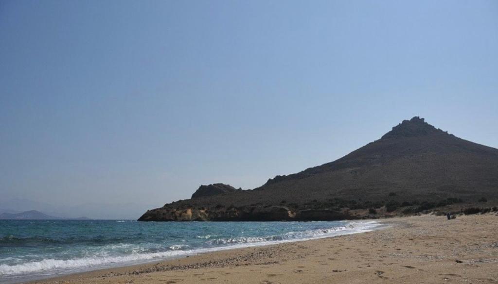 uma praia com uma montanha ao fundo em Louloudas rooms paros em Molos Parou