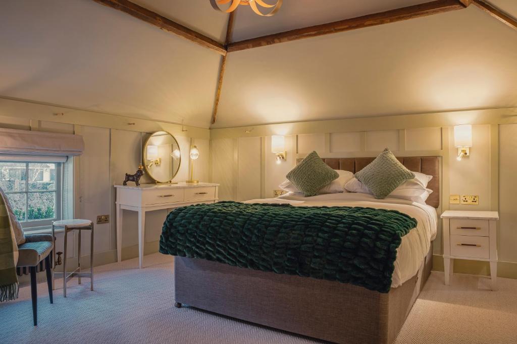 a bedroom with a large bed with a green blanket at Chris Wheeler at The Crown Inn in Buckinghamshire
