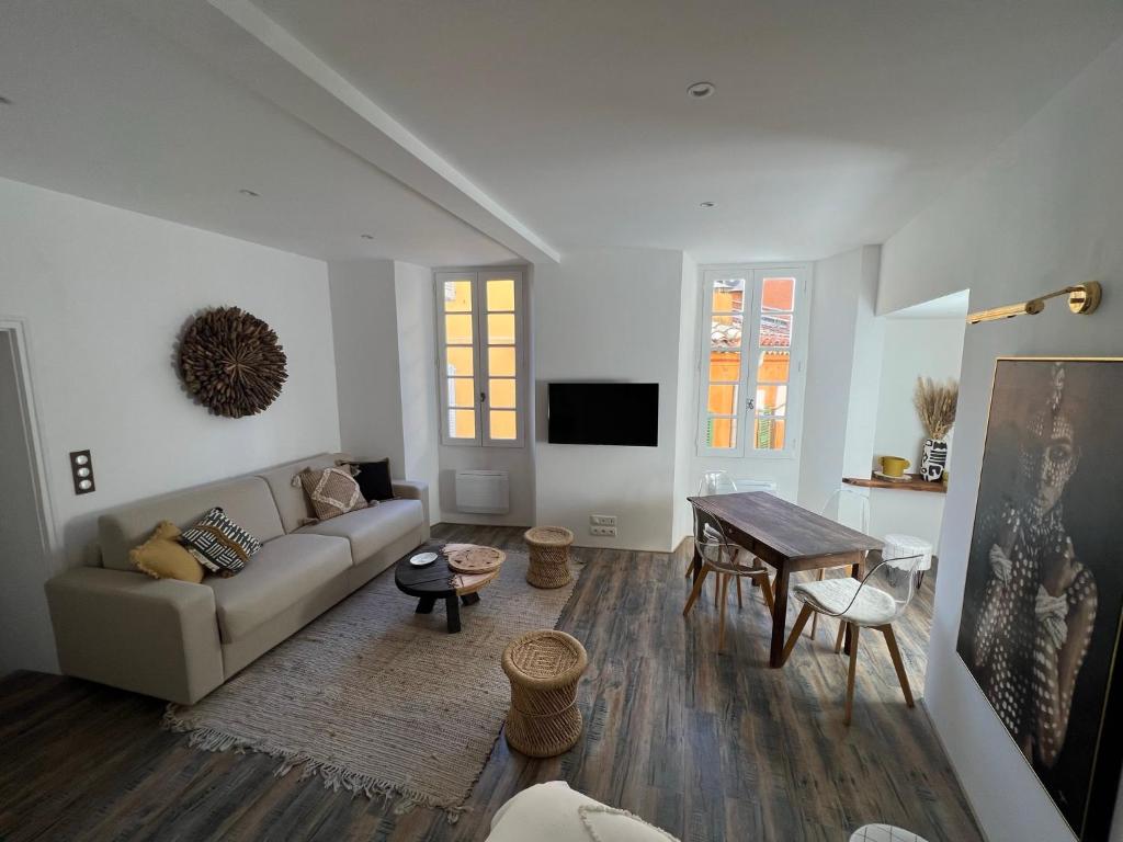 uma sala de estar com um sofá e uma mesa em L'AIR DU TEMPS, Superbe appartement, au coeur du Centre Historique de Grasse em Grasse