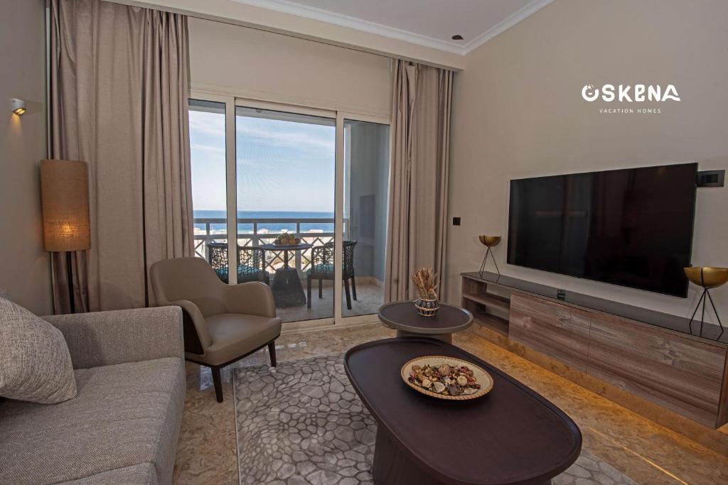 OSKENA Vacation Homes-Red Sea View Azzurra Salh Hasheesh Hurghada في الغردقة: غرفة معيشة مع أريكة وتلفزيون وطاولة