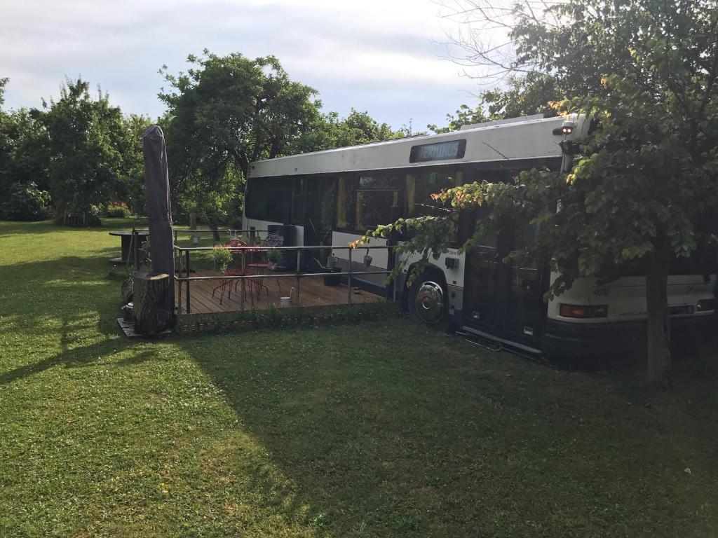 un bus garé sur l'herbe dans un champ dans l'établissement TERMINUSBUS, à Crèvecoeur-le-Grand