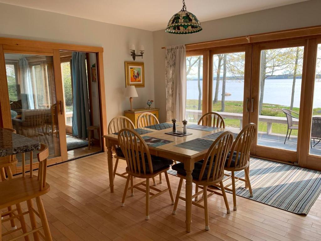 a dining room with a wooden table and chairs at Grey Ledge in Deer Isle